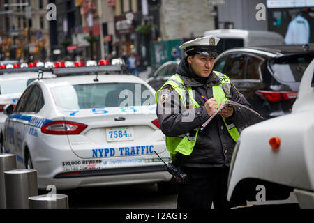 Oficial de tránsito para NYPD escribir un ticket de infracción de estacionamiento de Manhattan, en Nueva York, EE.UU. Foto de stock