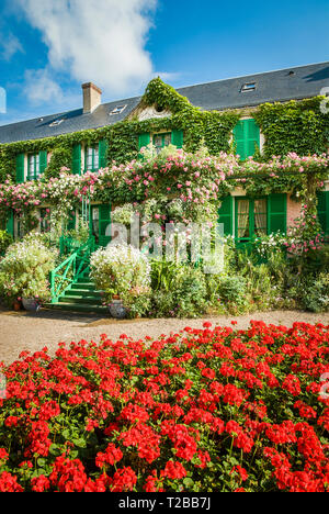 Una cama de geranios rojos delante de la entrada a la casa y el jardín de Monet en Giverny Francia Europeff Foto de stock