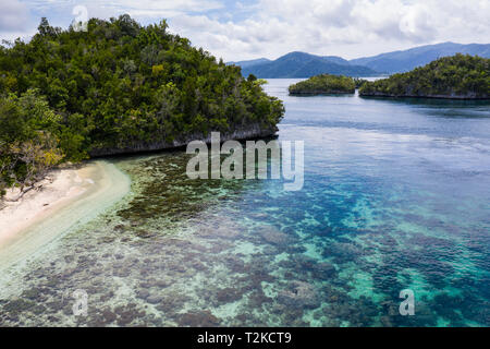 Islas de piedra caliza, rodeada por arrecifes de coral, se encuentran dispersas por toda la Raja Ampat seascape. Esta región es conocida por su biodiversidad marina. Foto de stock