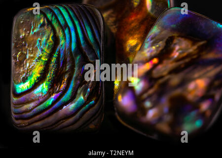Resumen antecedentes de piedras preciosas, nácar multicolor sobre fondo negro brillante Foto de stock