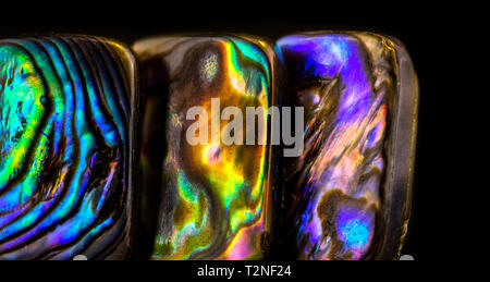 Resumen antecedentes de piedras preciosas, nácar multicolor sobre fondo negro brillante Foto de stock