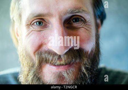 Close Up retrato de un hombre con una barba está hablando y riéndose. El concepto de comunicación gozosa. Imitar las arrugas alrededor de los ojos.