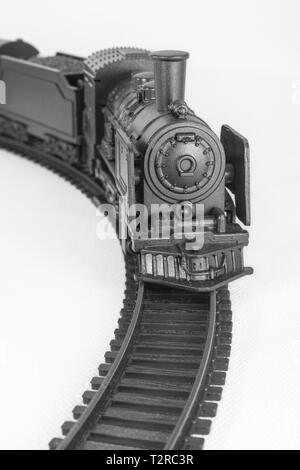Juguete pintado negro modelo de motor de vapor y pista. La metáfora de la derecha Vía, chollo, antiguos ferrocarriles, ferrocarril, tren de juguete, pista de carrera. Foto de stock