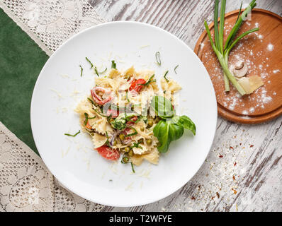 Póster para restaurantes. Ensalada con pasta, gambas, guisantes y decorado de hierbas. Sobre un fondo claro. Flay laical. Vista superior