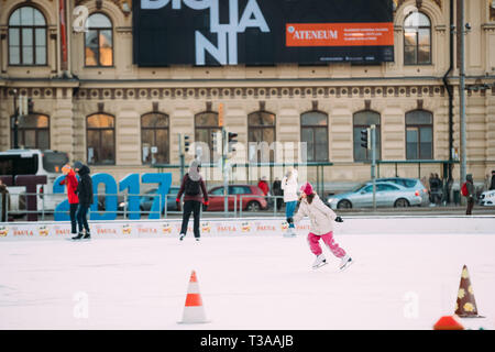 Helsinki, Finlandia - 11 de diciembre de 2016: Jóvenes y Niños patinando sobre hielo en la Plaza del Ferrocarril en el día de invierno.