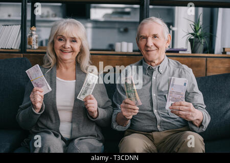 Las Personas Mayores Felices Con Euro Y De Dólar Billetes Y Hucha Que  Detienen Los Pulgares Fotos, retratos, imágenes y fotografía de archivo  libres de derecho. Image 27497278