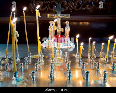 Las velas encendidas ante el crucifijo en el interior de una iglesia ortodoxa