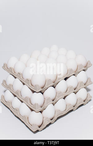 Huevos blancos de una gallina en inofensivos, embalaje de cartón sobre un fondo blanco. 3 packs. Foto de stock