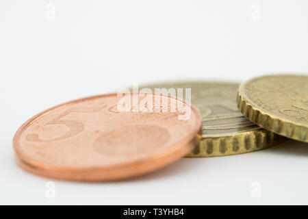 Las monedas de 5 céntimos de euro, 50 céntimos de euro y diez céntimos de euro sobre un fondo blanco. Foto de stock