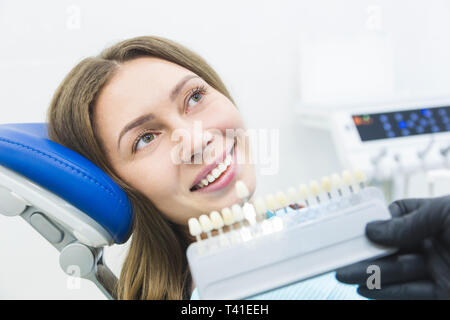 Clínica Dental. La recepción, el examen del paciente. Cuidado de los dientes. Dentista con muestras de color de diente elegir la sombra para mujeres en dental de los dientes del paciente cl Foto de stock