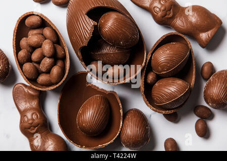 Conejitos y huevos de pascua de chocolate sobre un fondo de mármol Foto de stock