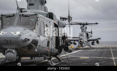 Océano Pacífico (Feb. 20, 2019) U.S. Marine Corps pilotos con medio marino Tiltrotor Escuadrón 163 (reforzado), la 11ª Unidad Expedicionaria de los Infantes de Marina (MEU), se preparan para despegar en un UH-1Y Venom (delantero) y un AH-1Z Viper del San Antonio clase dock buque anfibio de transporte USS John P. Murtha (LPD 26). Los infantes de Marina y marineros de la 11ª MEU están realizando operaciones rutinarias como parte del boxeador Amphibious Ready Group en el océano Pacífico oriental.