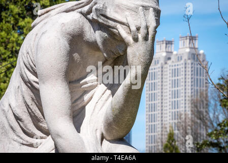 La mujer llorando estatua en el lote gris en el histórico Cementerio de Oakland con el centro de Atlanta, Georgia's 191 Peachtree torre en el fondo. (Ee.Uu.)