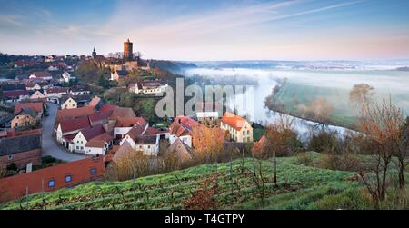 Vista de Schonburg Village y el castillo en el valle del Saale, niebla matutina en el Saale, cerca de Naumburg, Sajonia-Anhalt, Alemania Foto de stock