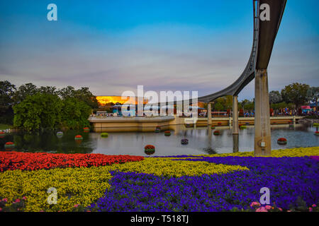 Orlando, Florida. Marzo 19, 2019. Carretera de monorraíl, coloridas flores y lago en el fondo del atardecer en Epcot en Walt Disney World . Foto de stock