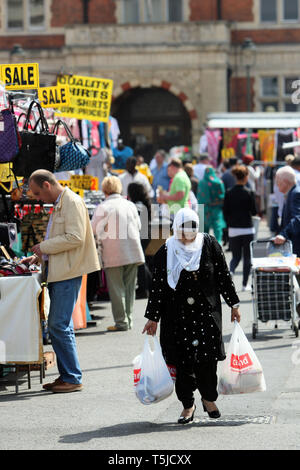 Los compradores atravesando el centro de la ciudad ladran puestos en el mercado. East London. 24 de abril de 2010. Foto de stock