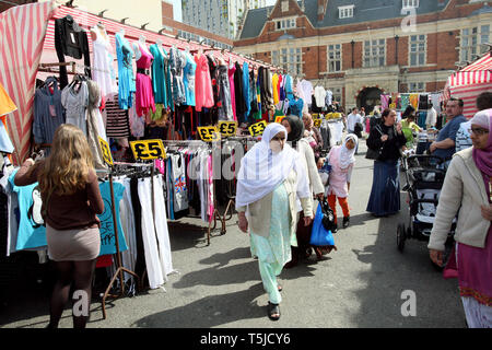 Los compradores atravesando el centro de la ciudad ladran puestos en el mercado. East London. 24 de abril de 2010. Foto de stock