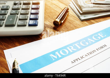 Formulario de solicitud de hipoteca, calculadora y dinero.