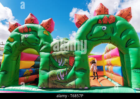 Castillo hinchable con forma de dinosaurios en una zona de juegos infantil  al aire libre Fotografía de stock - Alamy