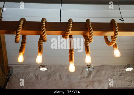 Bombilla de luz sin lámpara colgando del techo en la oscuridad. Iluminación  de un viejo y lúgubre habitación con espacio de copia Fotografía de stock -  Alamy