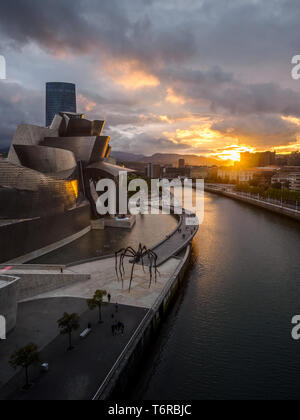 Cerca de Museo Guggenheim Bilbao riverside durante la puesta de sol, vista desde el puente de la salve
