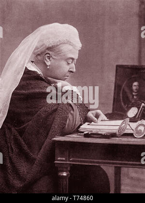La reina Victoria (1819-1901) con un retrato del Príncipe Alberto en su escritorio sobre 1899 Foto de stock