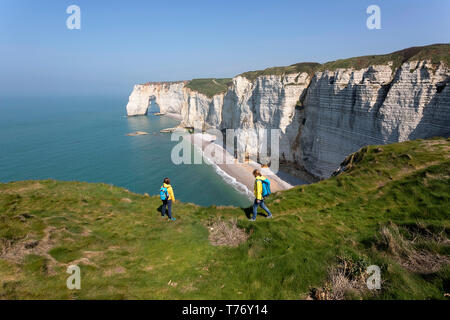 Francia, Normandía: Madre e hijo de pie sobre el césped cubierto de roca acantilados por encima del arco de Playa Etretat