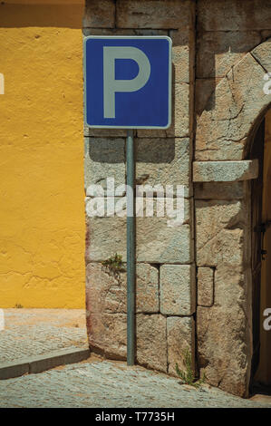 Señal de carretera aparcamiento en frente de la pared amarilla de yeso y piedra, ladrillos en Elvas. Una hermosa ciudad en la frontera oriental de Portugal.