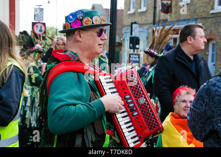 Festival barridos Rochester, Kent, UK. El 4 de mayo de 2019. El hombre vestido de verde juega un acordeón rojo en el acompañamiento al baile de bastones. Foto de stock