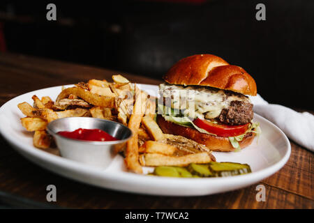 La chalota estragón Cheeseburger con patatas fritas, chapado de calidad restaurante Foto de stock