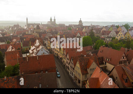 Vista aérea de la ciudad medieval de Rothenburg, su entramado de madera y coloridas casas en Rödergasse en un día lluvioso. Visible en el horizonte: ayuntamiento de... Foto de stock