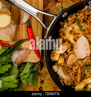 Pollo con Arroz frito con hierbas y especias en un sartén Foto de stock