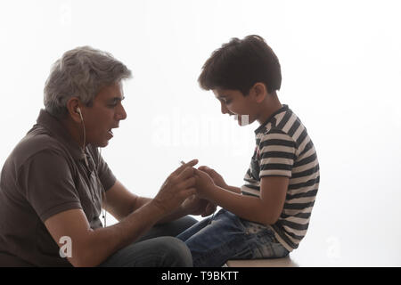 Abuelo y nieto de escuchar música con auriculares. Foto de stock