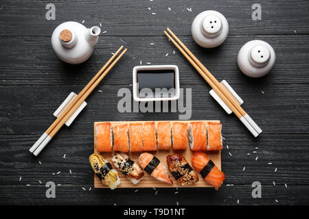 Composición con un sabroso sushi sobre fondo de madera oscura. Foto de stock
