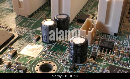 Resistencias, condensadores y otros componentes electrónicos en un equipo chapado de motherboard Foto de stock