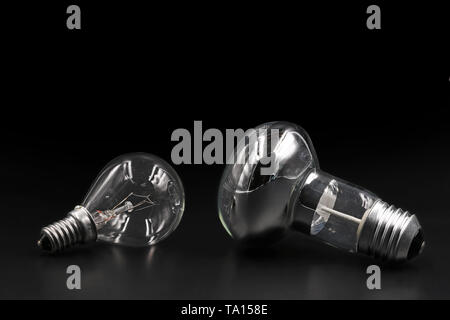 Dos tipos de bombillas sobre fondo negro con espacio de copia Foto de stock
