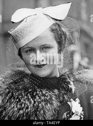 Mujer con un sombrero blanco con un arco y velo en Londres. Foto de stock