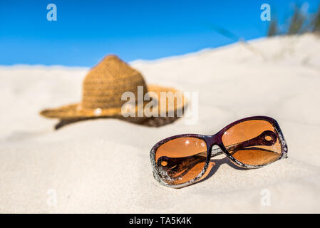 Gorra y gafas de sol sobre la arena. Accesorios de playa, vacaciones, vacaciones mar Báltico, Polonia Foto de stock