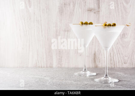 Classic Dry Martini con aceitunas sobre fondo gris. Copyspace