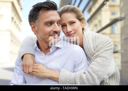 Retrato de la sonrisa afectuosa pareja abrazada al aire libre