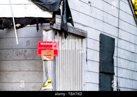 Atlanta, EE.UU. - Abril 21, 2018: Antigua casa abandonada de madera desgastada con entrada y aviso de advertencia signo rojo de bomberos Foto de stock