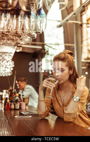 milenario de cabello marrón niña bebiendo té con pasteles solo Fotografía  de stock - Alamy