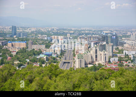 Vista panorámica de la ciudad de Almaty, con zona industrial, las montañas y el cielo con nubes. Visto desde Kok tobe, Kazajstán. Foto de stock