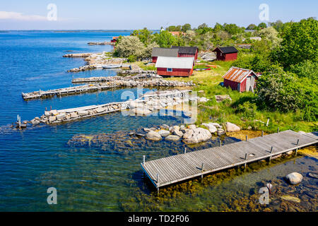 Campamento de pesca tradicional, típico de la costa sueca con embarcaderos de piedra y de madera pequeños cobertizos de pesca. Ubicación Isla Hasslo en Blekinge archipela Foto de stock