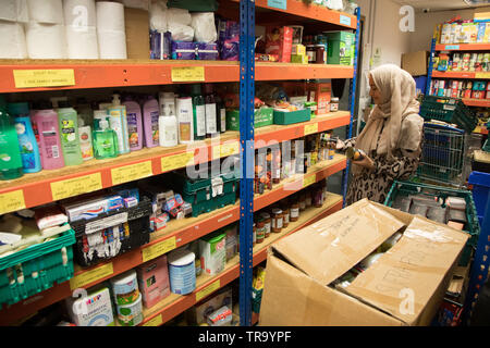 Una mujer musulmana con un velo bolsas de embalaje en un banco Foto de stock