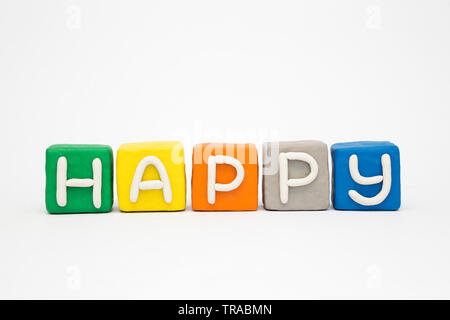 La palabra 'feliz' en los bloques de colores de arcilla Foto de stock