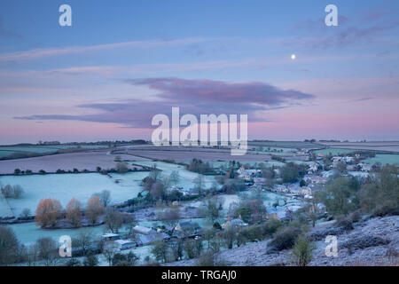 La menguante menguante Luna sobre Poyntington en una helada mañana de invierno, Dorset, Inglaterra, Reino Unido.
