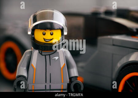 Tambov, Rusia - 21 de abril de 2019 Senna McLaren conductor minifigure Lego por LEGO y Campeones de la velocidad de su coche en el fondo. Foto de estudio. Foto de stock