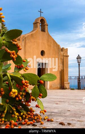 Cactus lleno de peras espinosas frente a un antiguo santuario en la vía romana a Castelmola, Sicilia Foto de stock