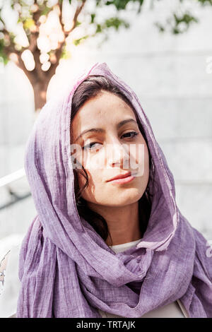 Retrato de joven bella niña islámica al aire libre con purple hiyab velo sobre la cabeza Foto de stock
